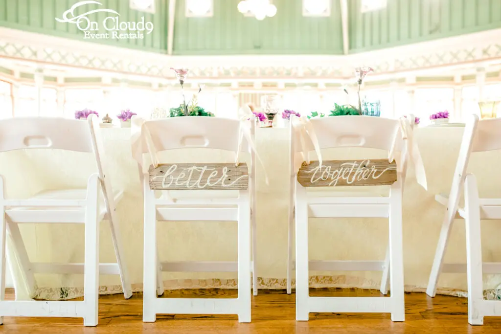 better together sign hanging on wedding reception chairs
