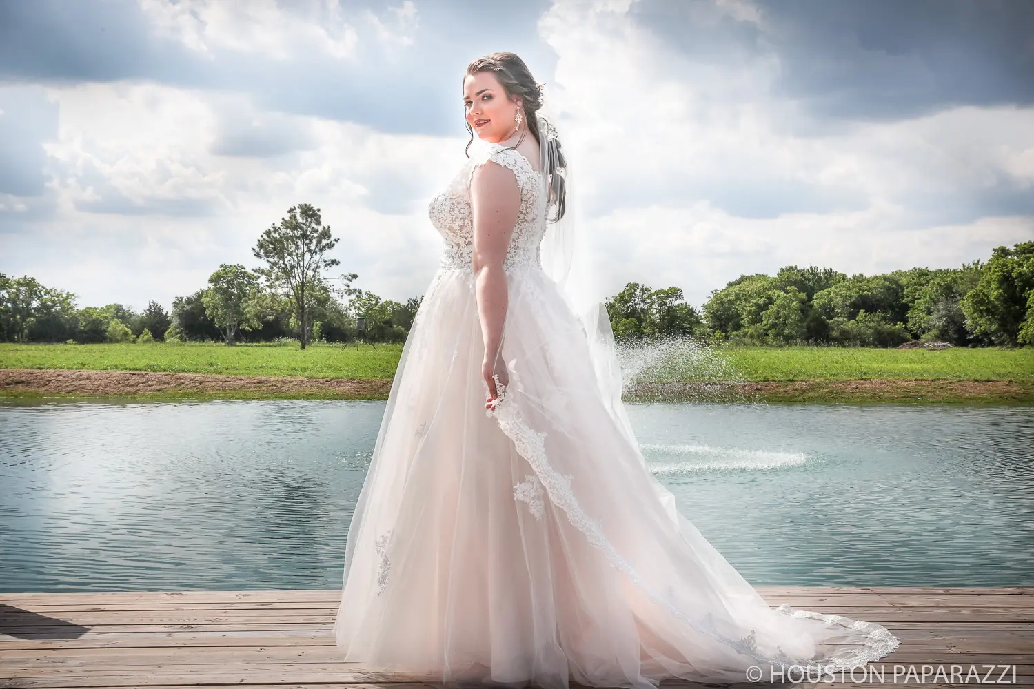 bride posing by the lake