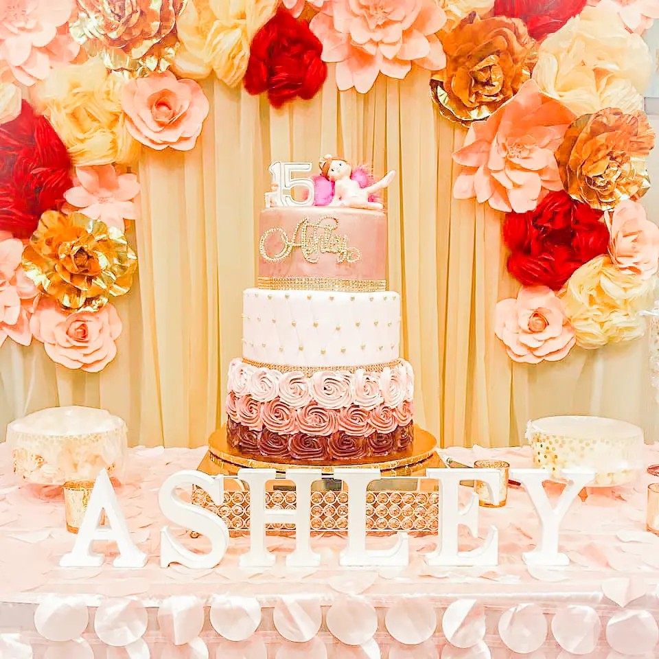 pink birthday cake and event flower backdrop
