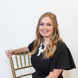 young blonde woman sitting on wedding reception chair